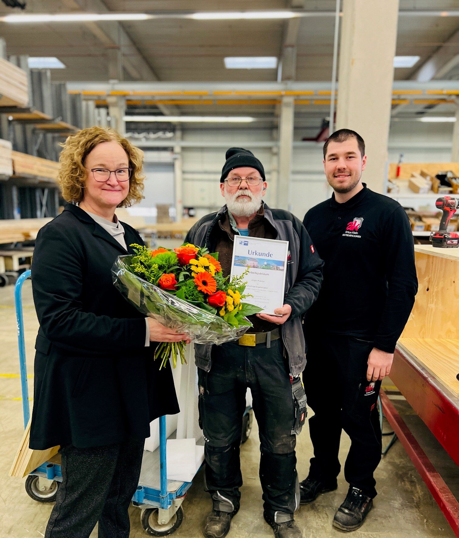 Maria Klein-Schmidt gratuliert Herr Puscher zu seinem 25-jährigen Dienstjubiläum bei Anton Klein